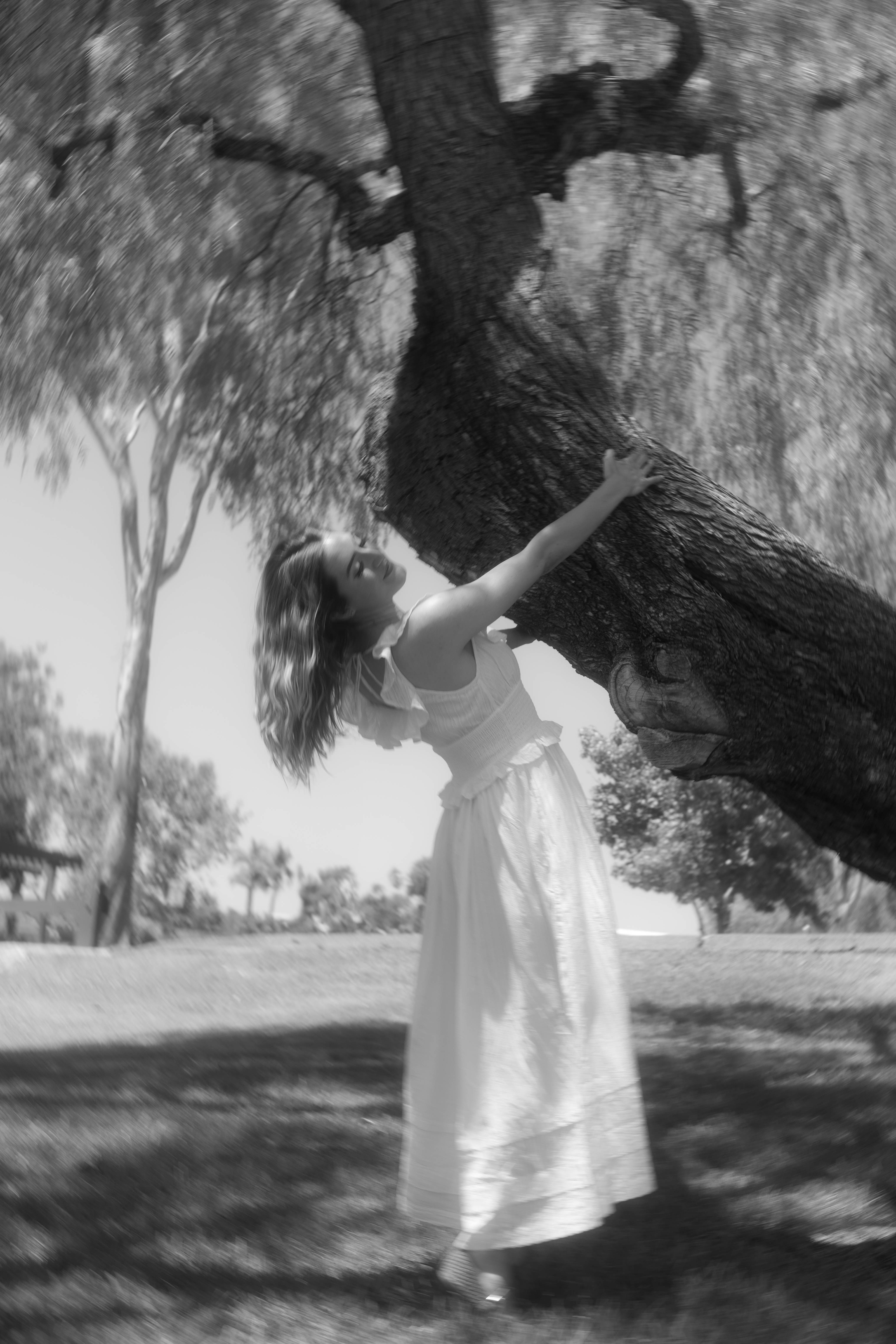Black and white image of a woman holding onto a tree, with a blurry effect, featured in the blog post showcasing the poem 'Do You Love Me Right' on Taylored Grace Survivor Support