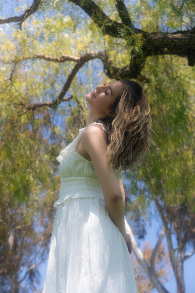 Woman standing under a tree reflecting on hope and healing through Christian faith after trauma